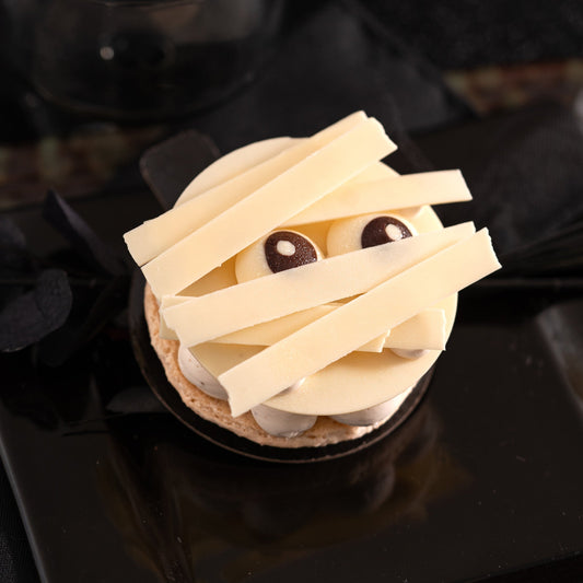 Mummy individual Halloween cake with mango passion fruit coulis, mascarpone vanilla cream and white chocolate.