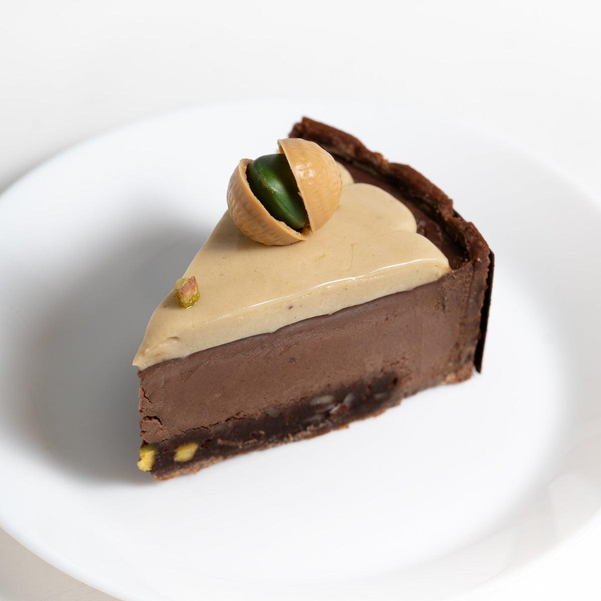 Rich pistachio brownie topped with creamy pistachio ganache and intense dark chocolate crème brûlée.